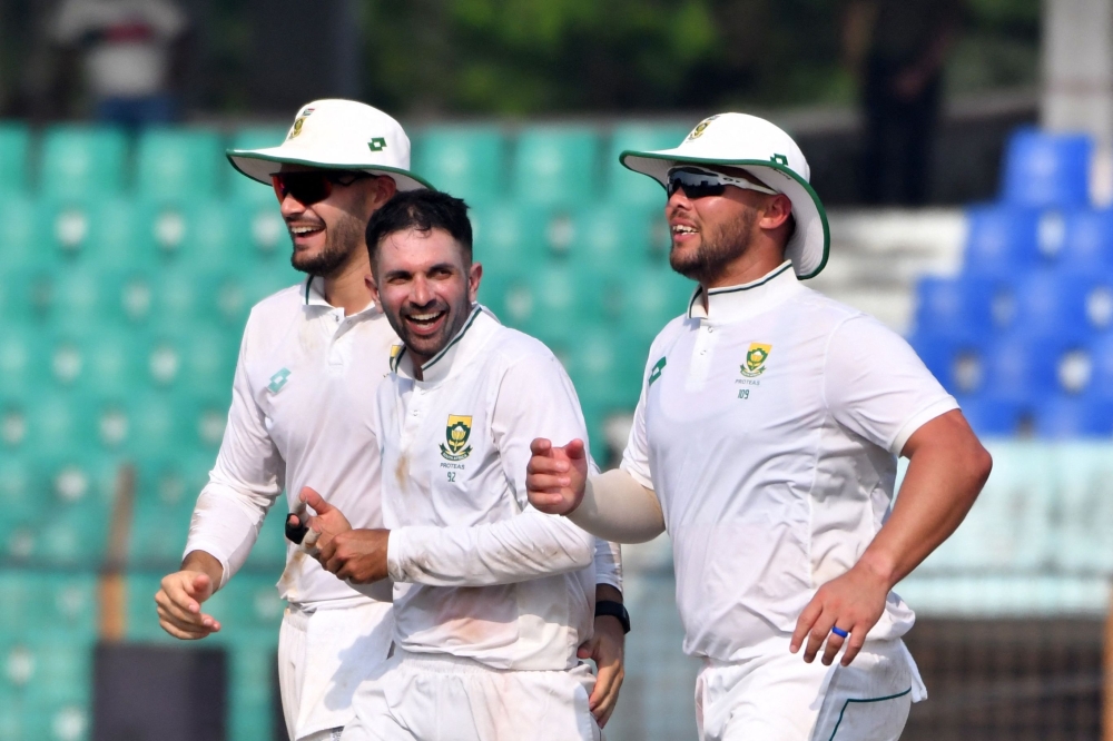 South Africa's Keshav Maharaj (C) celebrates with teammates after the dismissal of Bangladesh's Mominul Haque during the third day of the second Test cricket match between Bangladesh and South Africa at the Zahur Ahmed Chowdhury Stadium in Chittagong on October 31, 2024.  (Photo by TANVIN TAMIM / AFP)

