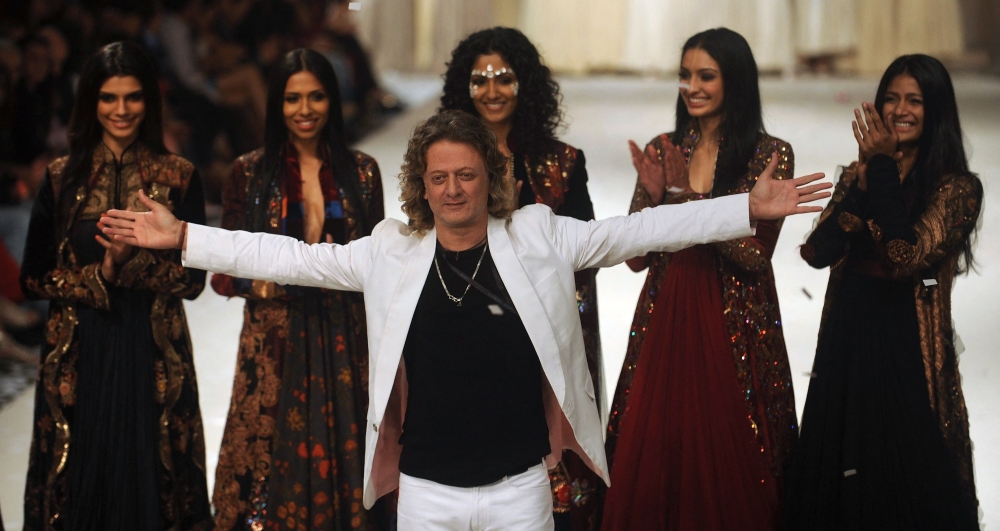 Indian designer Rohit Bal (C) poses with models 