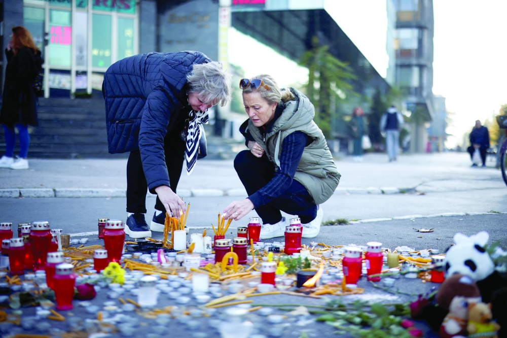 People light candles to pay their respects to those killed in the roof collapse in Novi Sad, Serbia. — AFP