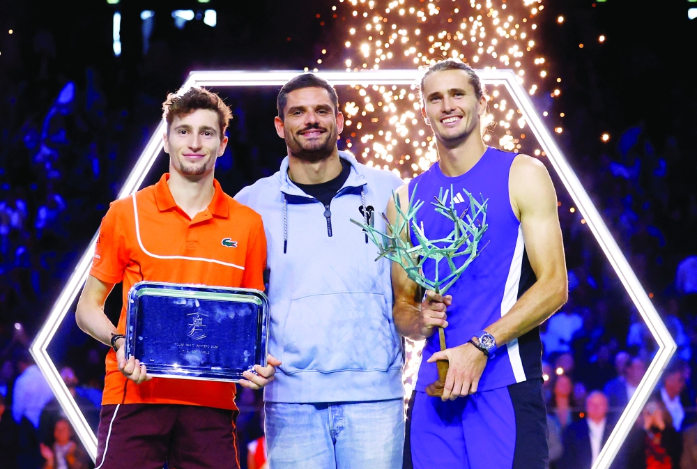 Tennis - Paris Masters - Accor Arena, Paris, France - November 3, 2024 Tournament winner Alexander Zverev of Germany and runner up Ugo Humbert of France alongside swimmer Florent Manaudou during the trophy presentation after their men's singles final match REUTERS/Stephanie Lecocq
