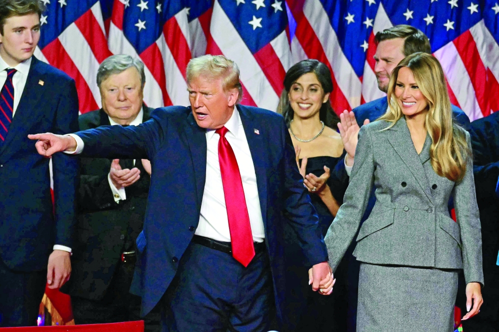 Former US President and Republican presidential candidate Donald Trump gestures at supporters after speaking as he holds hands with former US First Lady Melania Trump at the West Palm Beach Convention Center in West Palm Beach, Florida. — AFP 