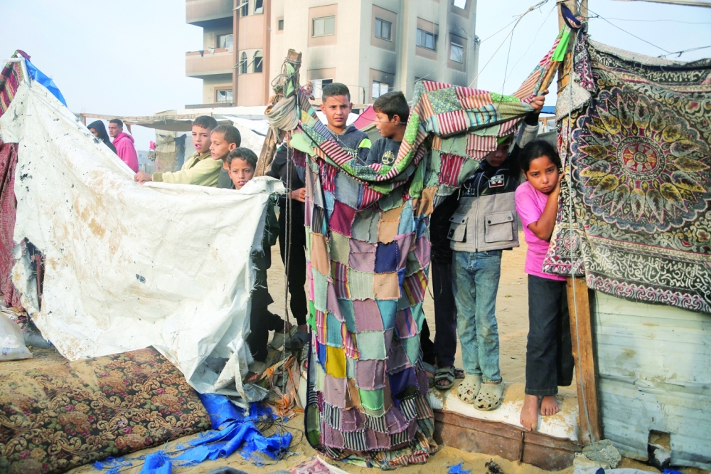 Palestinian children stand at the site of an Israeli strike on a tent housing displaced people in Khan Yunis. — Reuters