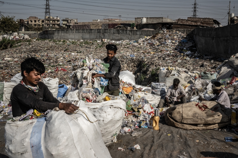 Scavengers at an informal garbage dump in Shahdara, a suburb of Delhi, India, Feb. 24, 2023. (Bryan Denton/The New York Times)