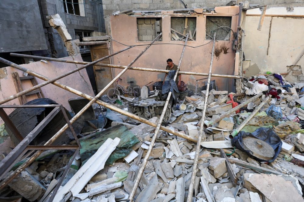 A Palestinian man inspects the site of an Israeli strike on a house in Nuseirat in the central Gaza Strip on Wednesday. — Reuters 
