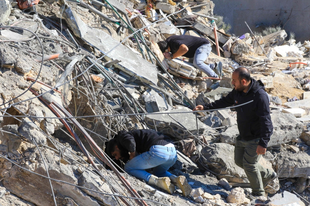 TOPSHOT - Rescuers search for survivors in the rubble of a house at the site of an overnight Israeli airstrike in Joun on November 13, 2024, amid the ongoing war between Israel and Hezbollah.  (Photo by Mahmoud ZAYAT / AFP)
