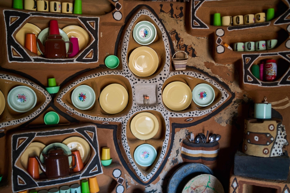A general view of plates and utensils placed decoratively in a mud painted kitchen in Matobo, Matabeleland on September 30, 2024. With its picturesque granite hills and balancing rocks, Matobo Hills is a UNESCO designated World Heritage Site, having the highest concentration of known rock paintings on the African continent, dating back to over a dozen millenia and has places that are considered sacred across Zimbabwe痴 various ethnic groups. (Photo by Zinyange Auntony / AFP)

