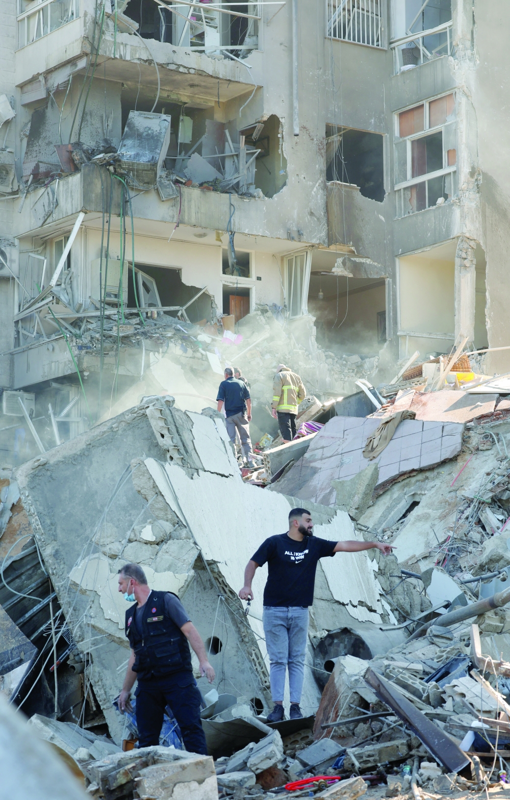 People stand on rubble at a damaged site in the aftermath of an Israeli strike in Tayouneh, Lebanon, on Friday. — Reuters