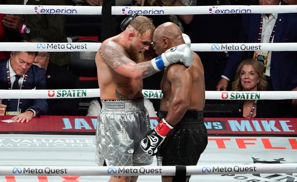 Mike Tyson and YouTuber/boxer Jake Paul hug after Paul defeated Tyson in their heavyweight boxing bout 