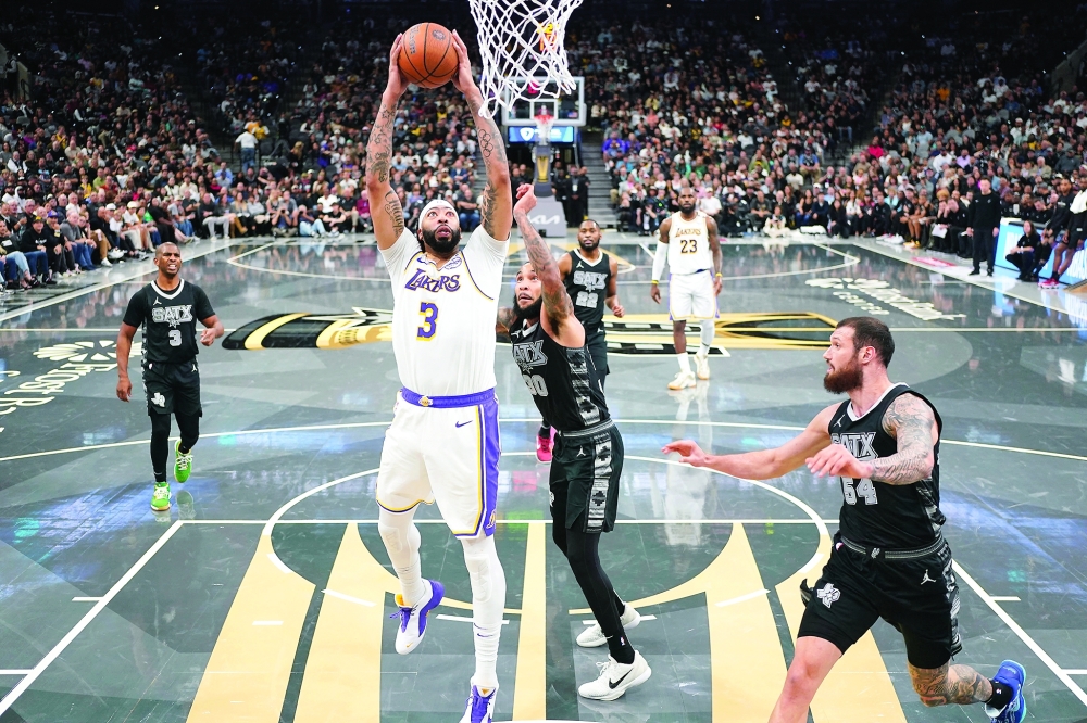 Anthony Davis (3) drives to the basket past Julian Champagnie (30). — Reuters