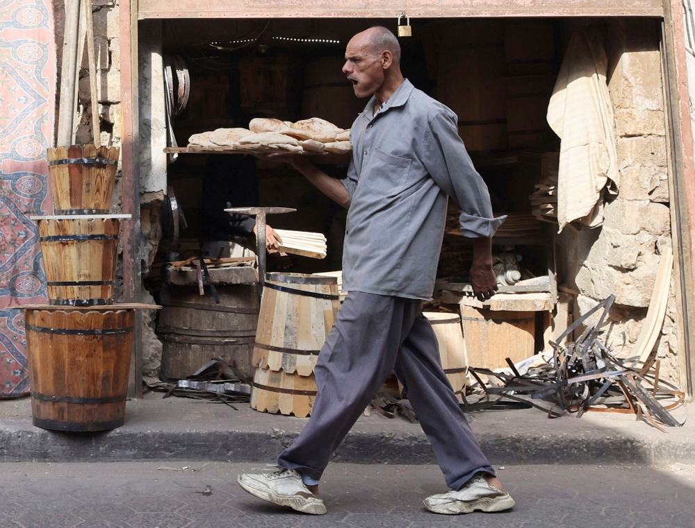 An Egyptian man carries bread bought from a bakery in Cairo, Egypt November 12, 2024. 