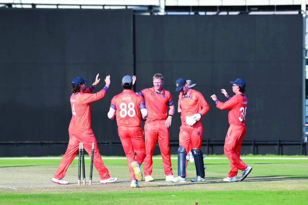 The Netherlands players celebrate a wicket against Oman.
