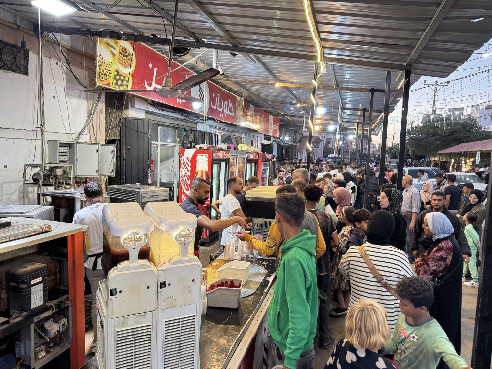 People visit a sweets and pastries shop in Deir al-Balah, Gaza, Oct. 21, 2024. (Bilal Shbair/The New York Times)