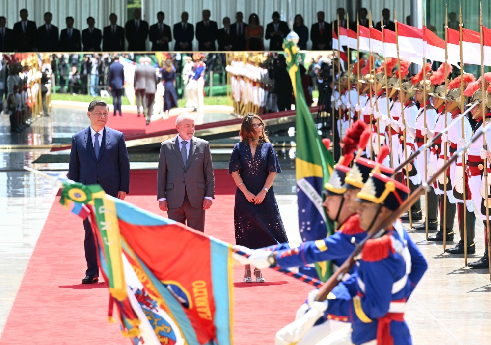 China's President Xi Jinping (L) receives military honors next to Brazil's President Luiz Inacio Lula da Silva and his wife Rosangela "Janja" da Silva at the Planalto Palace in Brasilia. — AFP 