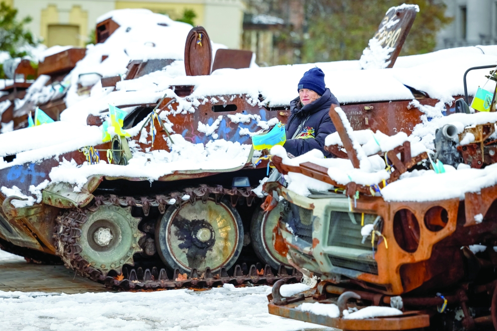 A woman stands on a snow-covered street during a snowfall in Kyiv. — Reuters