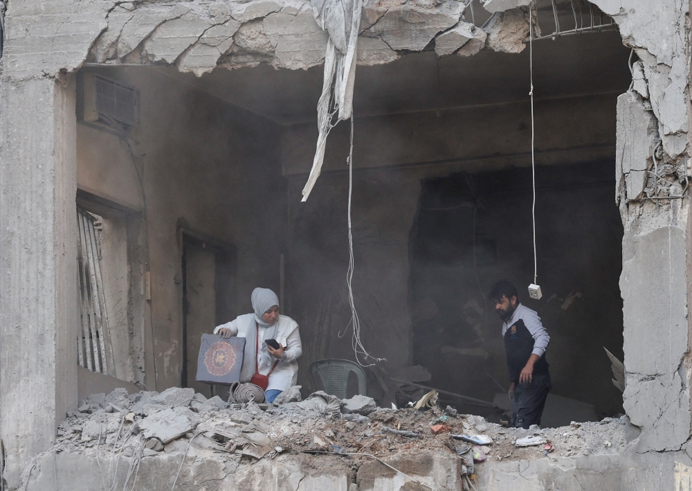 People search for their belongings inside a damaged building in the aftermath of an Israeli strike in Beirut. — Reuters 