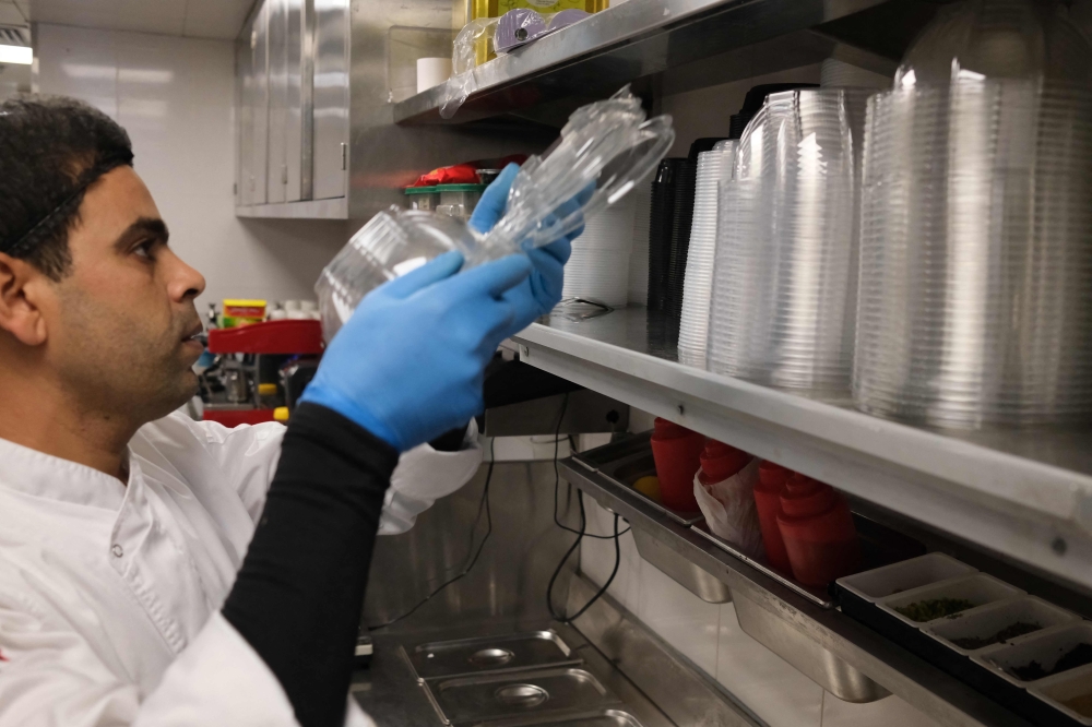 A chef packages takeaway food at a restaurant 