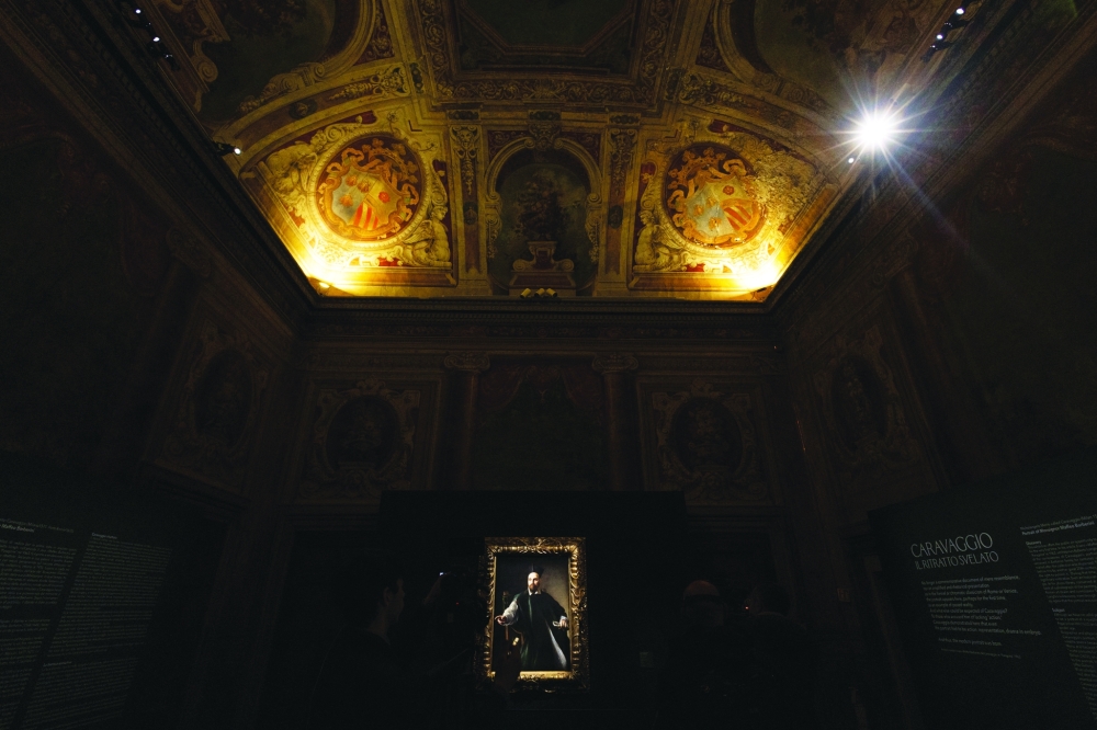 People stand near Caravaggio's Portrait of Monsignor Maffeo Barberini which was unveiled at the National Gallery of Ancient Art, before going on public display for the first time in Rome, Italy, November 22, 2024. REUTERS/Remo Casilli