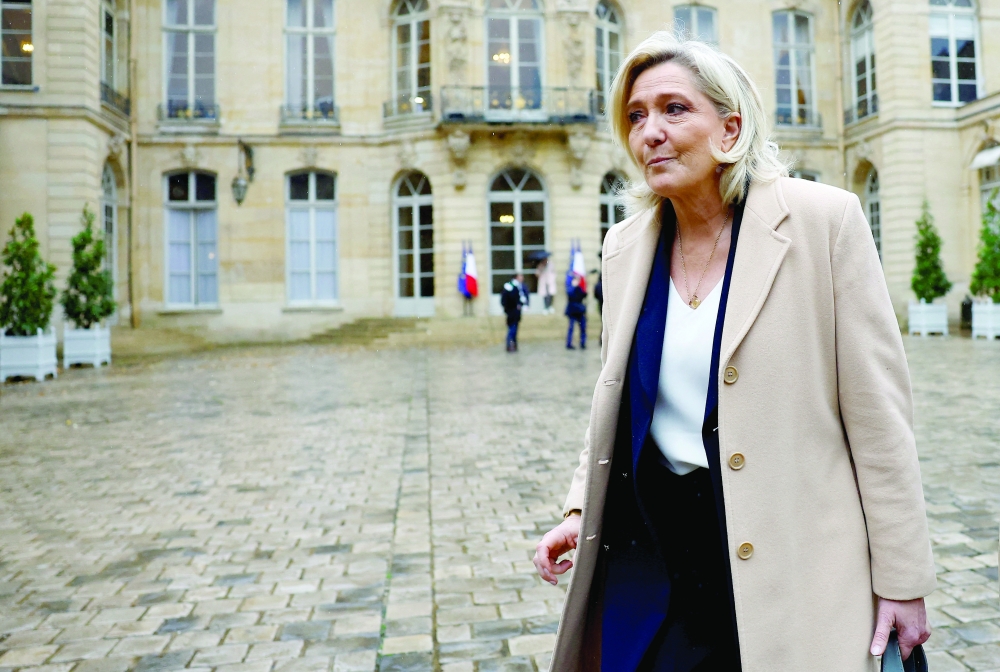 French far-right leader Marine Le Pen leaves after a meeting with the French PM, in Paris. — Reuters 