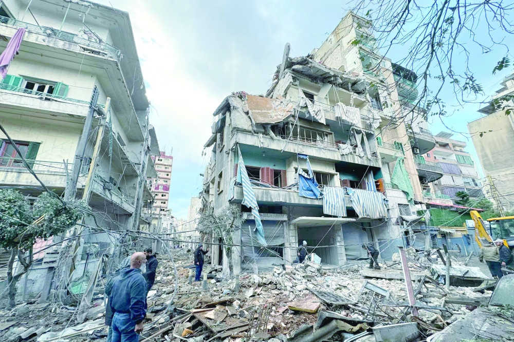 People inspect the damage at the site of overnight Israeli air strikes that targeted the neighbourhood of Ghobeiry in Beirut. — AFP