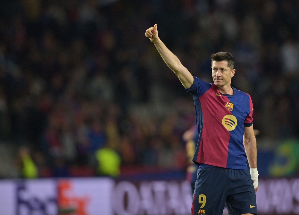 Barcelona's Polish forward #09 Robert Lewandowski celebrates victory at the end of the UEFA Champions League, league phase day 5 football match between FC Barcelona and Stade Brestois 29 (Brest) at the Estadi Olimpic Lluis Companys in Barcelona, on November 26, 2024. Barcelona won 3-0. (Photo by MANAURE QUINTERO / AFP)

