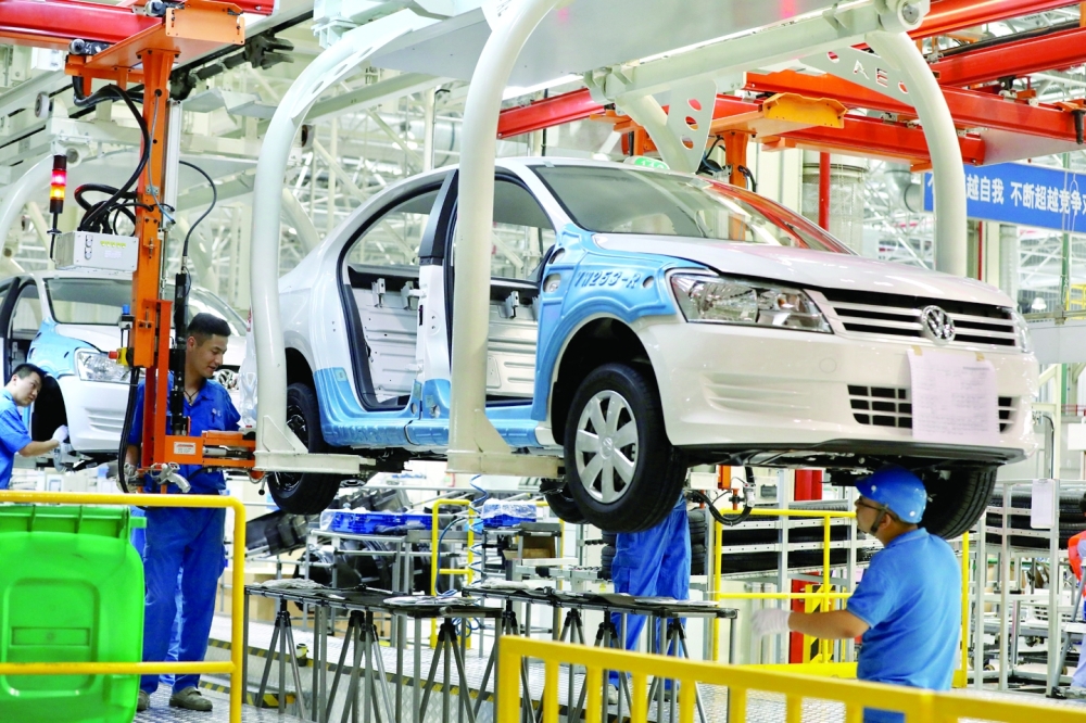 Employees work on assembling vehicles at a plant of SAIC Volkswagen in Urumqi, Xinjiang Uighur Autonomous Region, China. - Reuters File