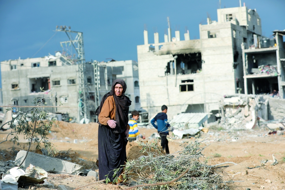 A Palestinian woman reacts near damaged buildings after Israeli forces withdrew from a part of Nuseirat in central Gaza Strip. - Reuters