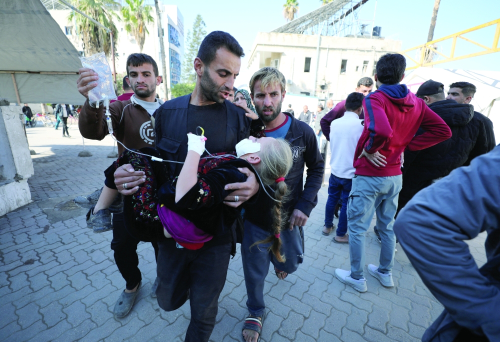 A wounded Palestinian girl is carried to the hospital, in the aftermath of an Israeli strike, in Gaza City. — Reuters