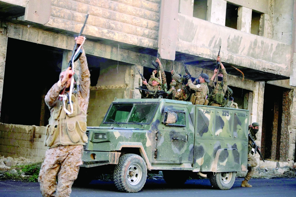 Anti-government fighters on a street in Maaret al Numan in Syria's northwestern Idlib province on Saturday. - AFP