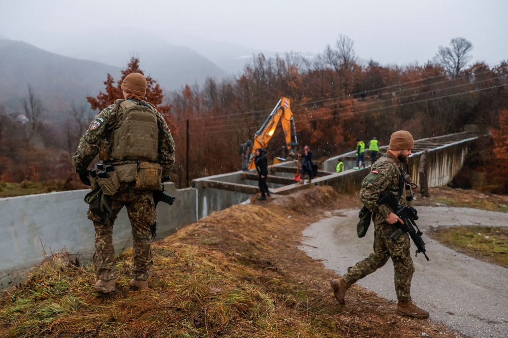 Latvia's soldiers, part of the Nato-led peacekeeping force KFOR, patrol near the damaged canal in northern Kosovo. — Reuters