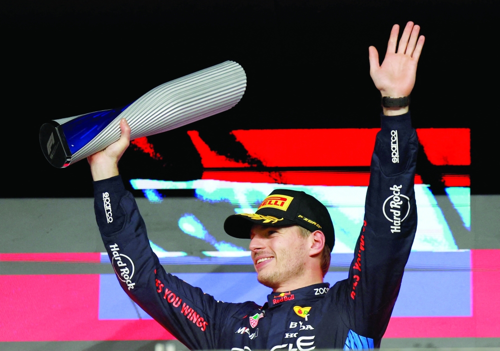 Formula One F1 - Qatar Grand Prix - Lusail International Circuit, Lusail, Qatar - December 1, 2024  Red Bull's Max Verstappen celebrates with a trophy on the podium after winning the Qatar Grand Prix. REUTERS