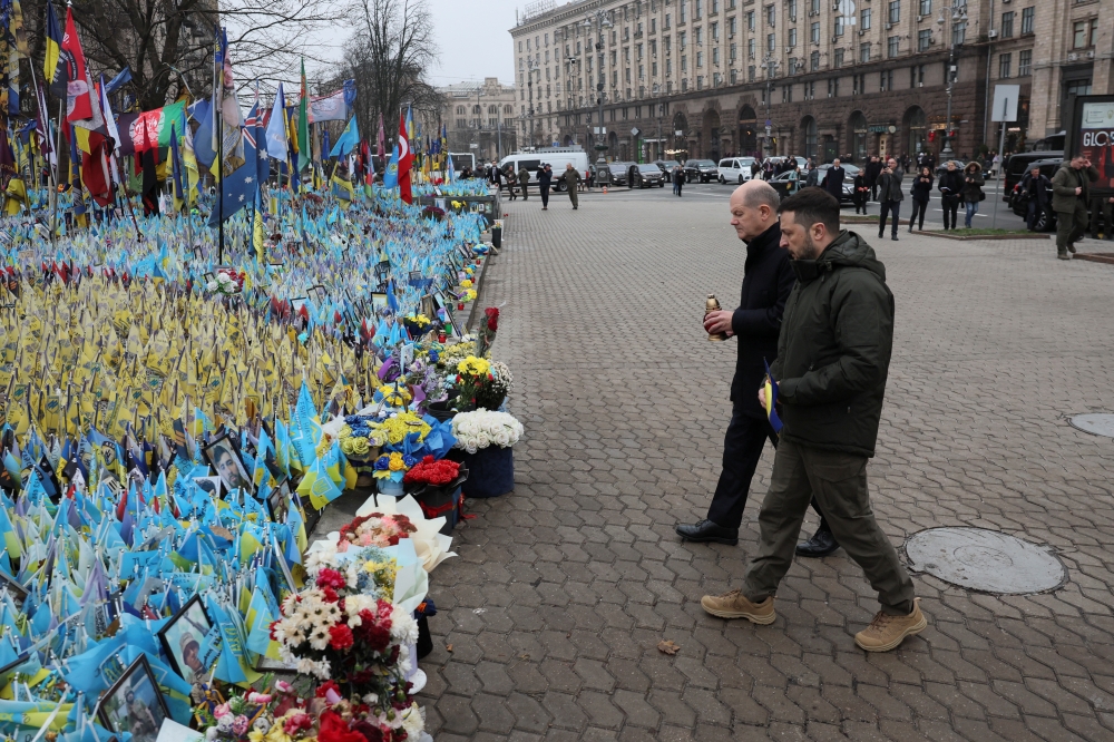 Ukraine's President Volodymyr Zelenskiy and German Chancellor Olaf Scholz visit a makeshift memorial place displaying Ukrainian flags, in Kyiv. — Reuters 