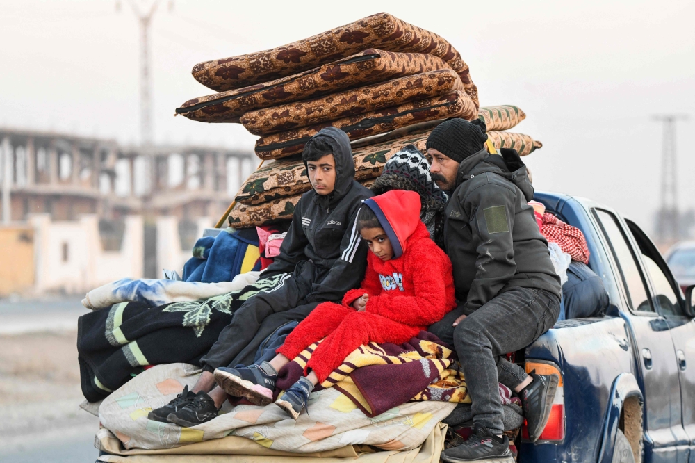 Displaced Syrians drive vehicles loaded with belongings to flee areas on the outskirts of the northern city of Aleppo