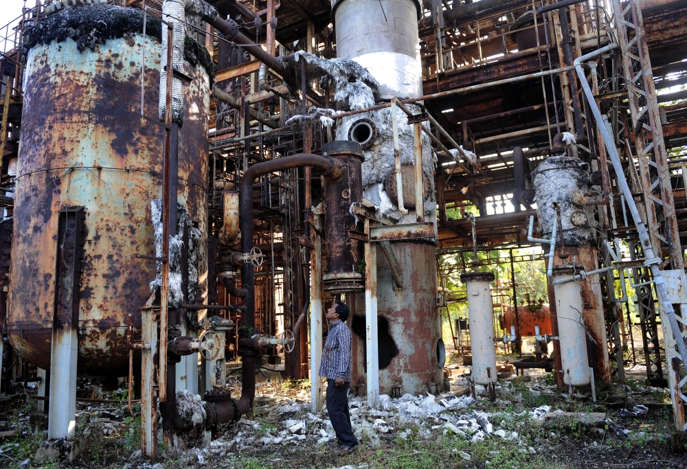 A man looks at discarded machinery at the now-defunct Union Carbide factory in Bhopal 
