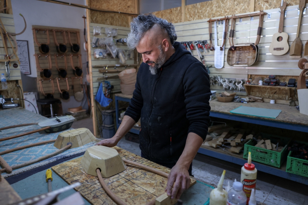 Danis Koumartzis, 41, works on the replica of an ancient Greek lyre in his workshop in Evropos, northern Greece, November 18, 2024. REUTERS/Alexandros Avramidis
