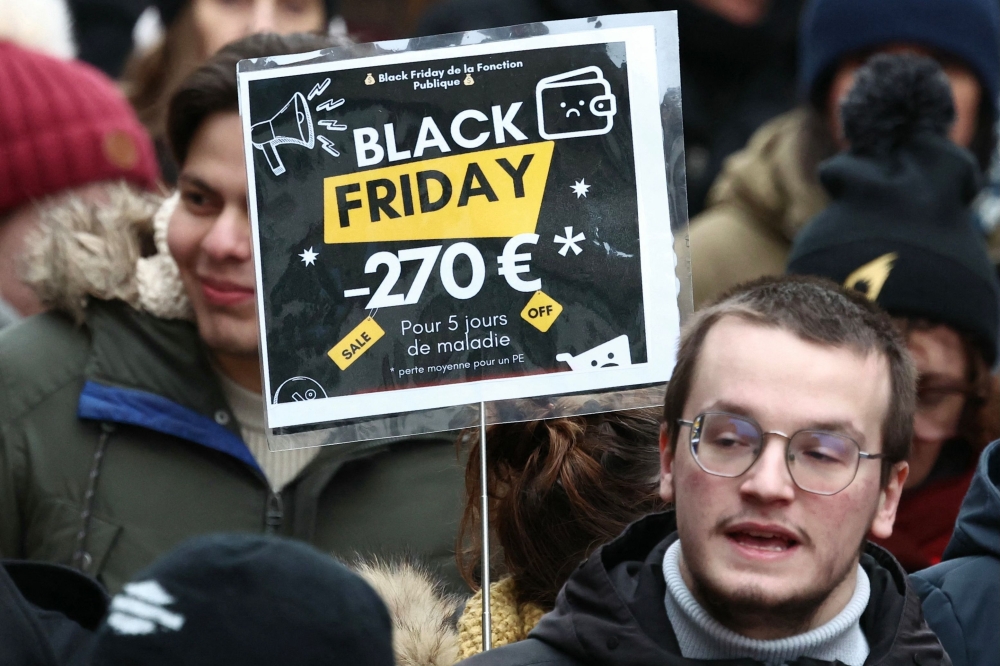 A protester holds a placard reading 'Black Friday -250 euro for 5 sick days' during a demonstration as part of a day of nation-wide strikes and demonstrations called by unions representing civil service agents, as part of a day of action and strike in the public sector, in Strasbourg. - AFP