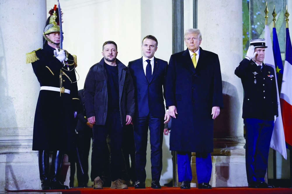 French President Emmanuel Macron accompanies US president-elect Donald Trump and Ukraine's President Volodymyr Zelensky as they leave after a trilateral meeting at the Elysee Palace in Paris. — Reuters