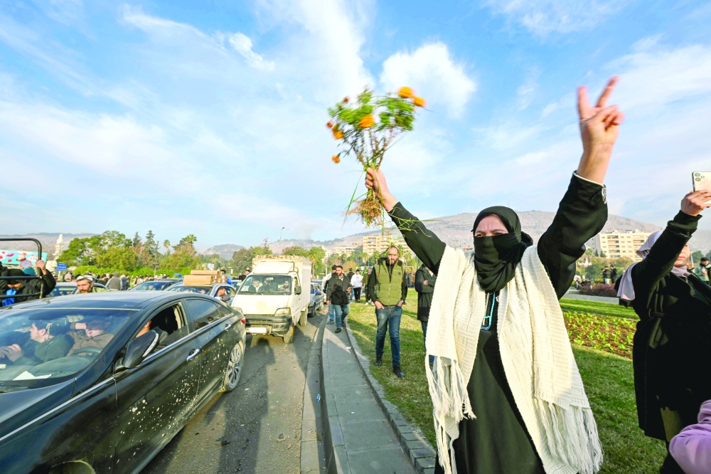 People celebrate at Umayyad Square in Damascus. — AFP 
