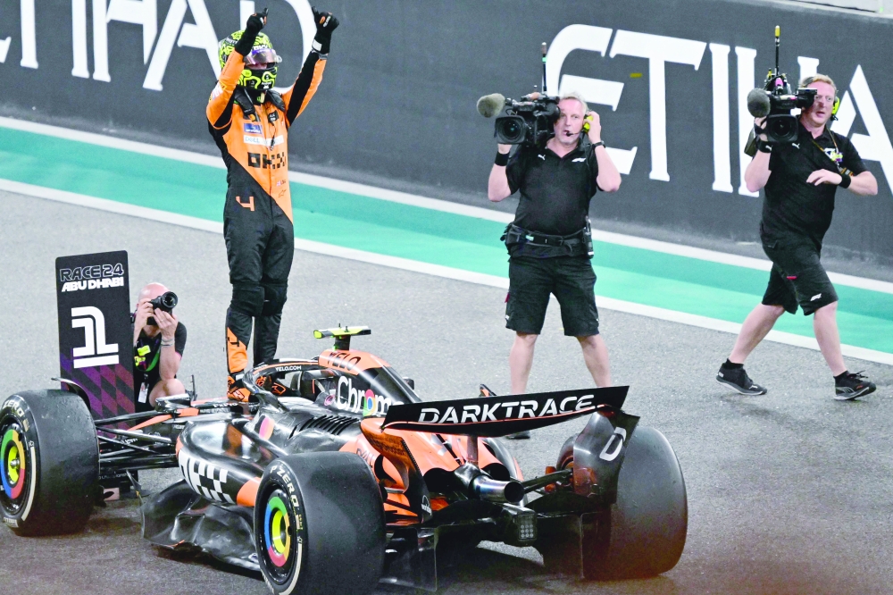 McLaren's British driver Lando Norris celebrates after the winning. — AFP