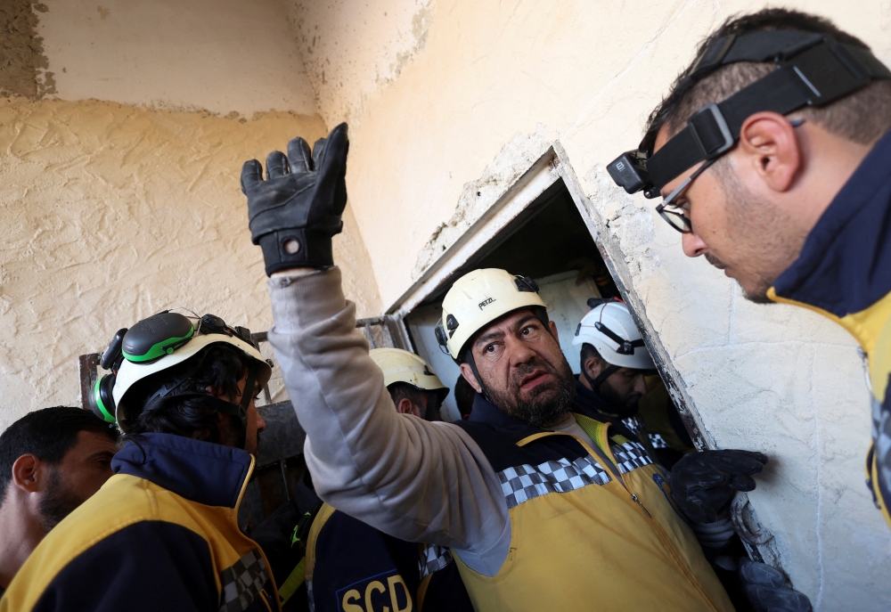 Members of the Syrian civil defence group search for prisoners at Sednaya prison, Syria. — Reuters 