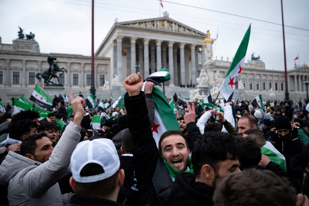 Syrian people react, as they gather in front of Parliament, in Vienna, Austria. — Reuters 