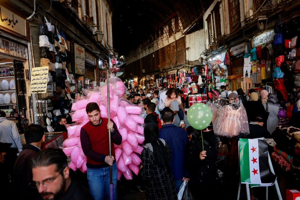 People walk at a souk, after Syrian rebels announced that they have ousted Bashar al Assad, in Damascus old city. - Reuters

