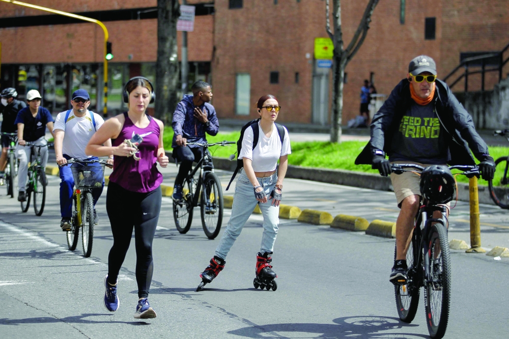 People jogging and riding on a bike path are seen during a weekly car-free day in Bogota. — AFP