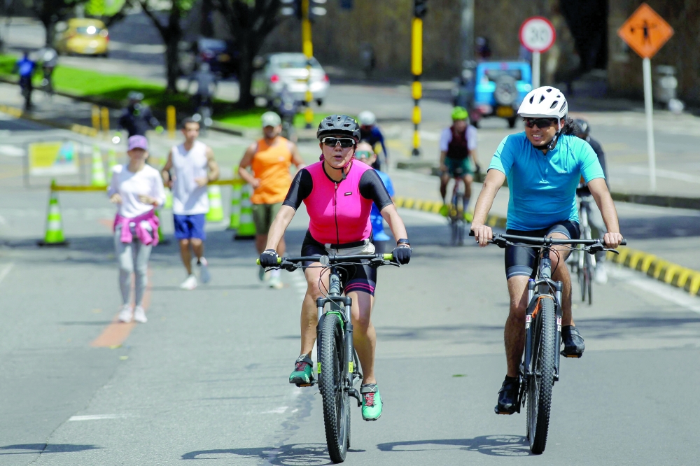 Cyclists ride on a bike path during a weekly car-free day in Bogota. — AFP