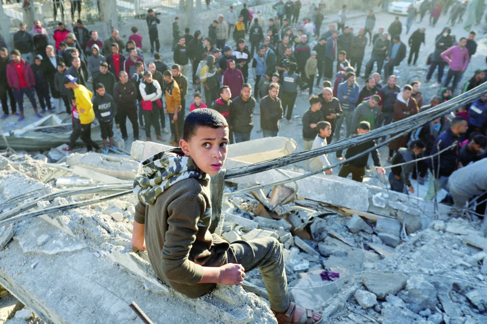A boy sits at the site of an Israeli strike at the Nuseirat refugee camp in the central Gaza Strip on Friday. — Reuters