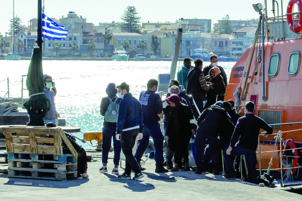 Migrants disembark a Hellenic Coast Guard