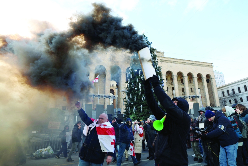 Demonstrators gather as parliament members elected Mikheil Kavelashvili as a new president in Tbilisi. — AFP