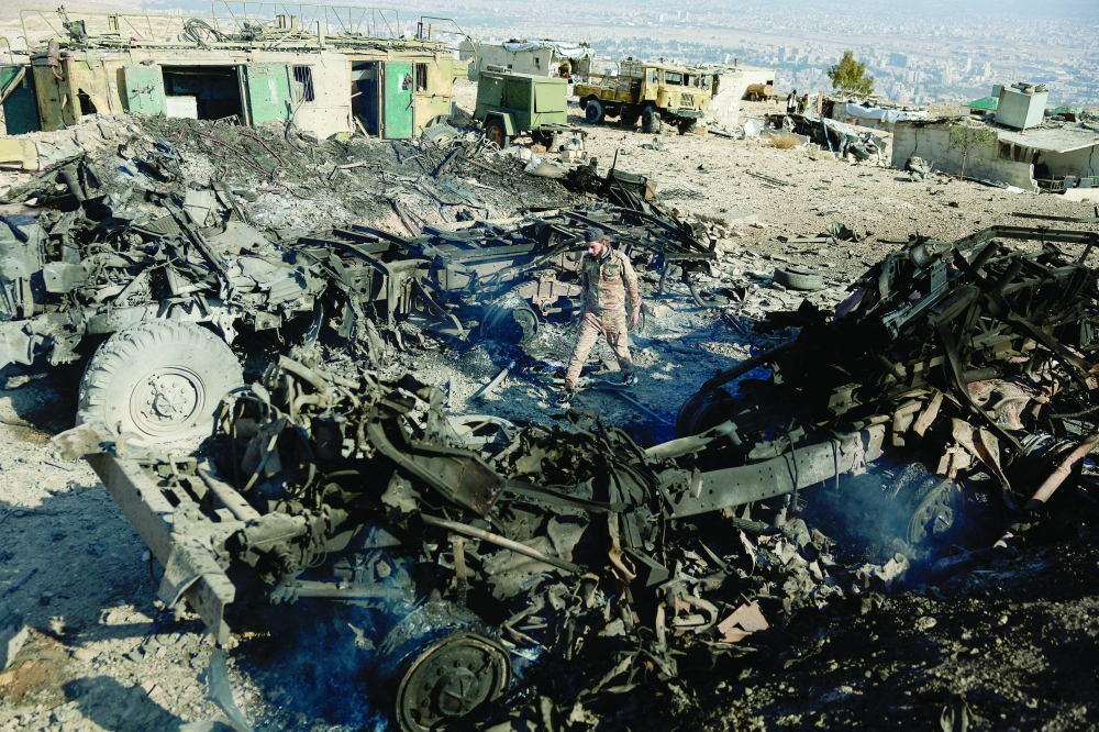 A fighter of the ruling Syrian body inspects the damage at a military site, in the aftermath of an Israeli strike, in Damascus. — Reuters