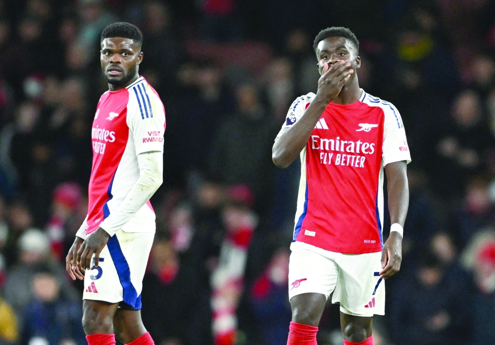 Thomas Partey and Bukayo Saka look dejected after the match. REUTERS