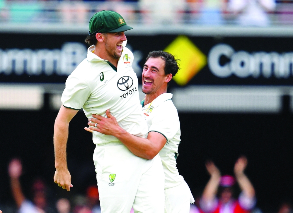 Cricket - Third Test - Australia v India - Brisbane Cricket Ground, Brisbane, Australia - December 16, 2024 Australia's Mitchell Marsh and Mitchell Starc celebrate taking a wicket  Jono Searle/AAP Image via REUTERS
