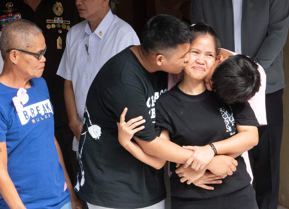 Mary Jane Veloso (2nd R) is reunited with her two sons and her father (L) 